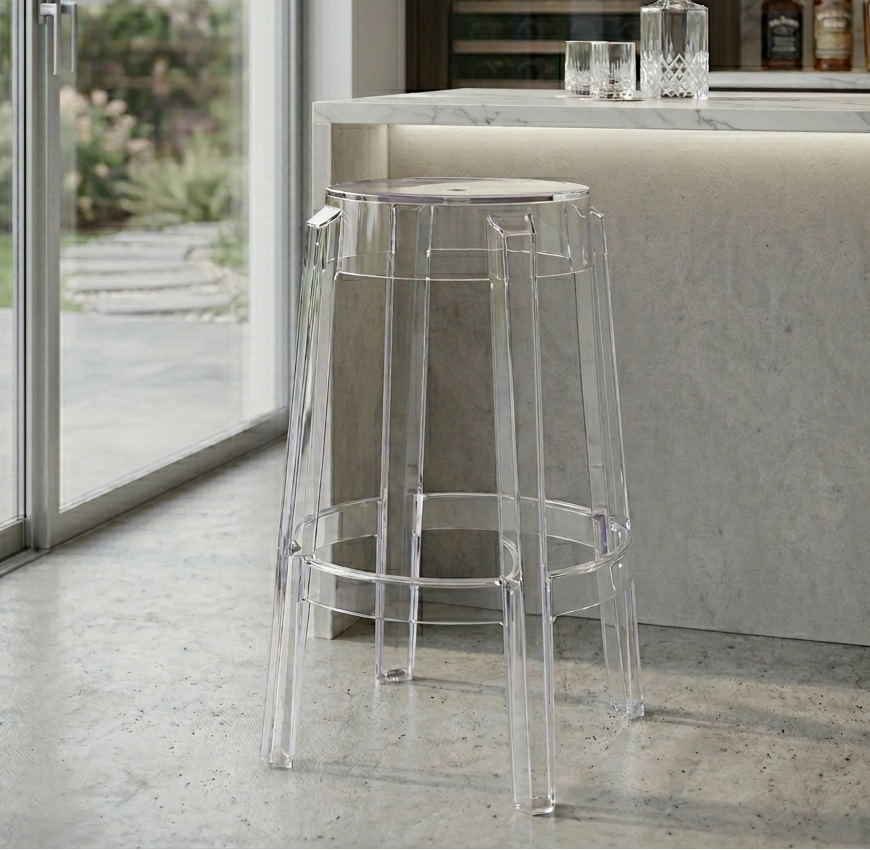 Clear bar stool in a modern kitchen setting with a view of a garden.