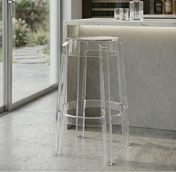 Clear bar stool in a modern kitchen setting with a view of a garden.