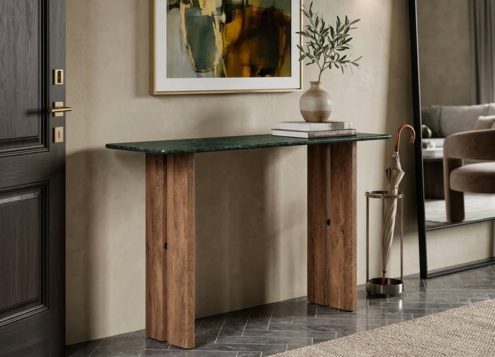 Console table witha a green marble top and wooden base in a room with abstract art and a mirror.