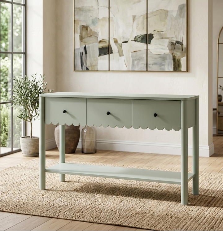 Light green console table in a room with abstract art on the wall and large windows.
