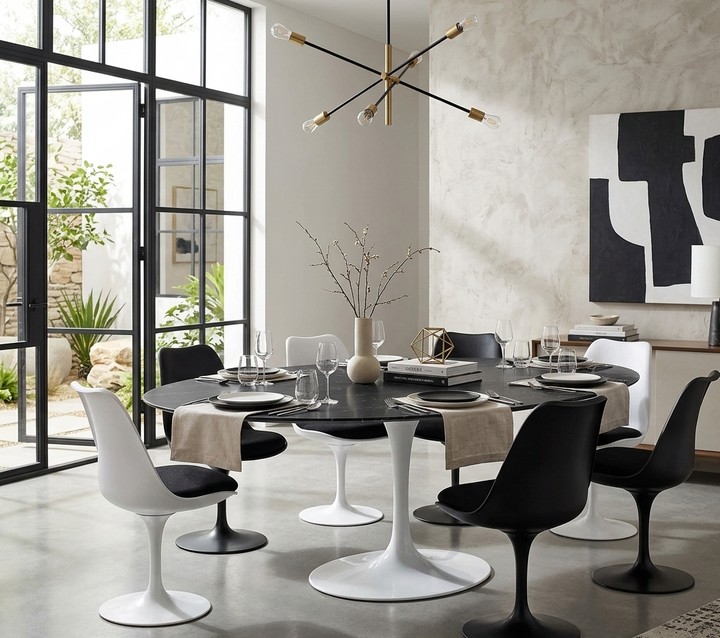 Modern dining room with a black and white color scheme, featuring a round table and chairs.