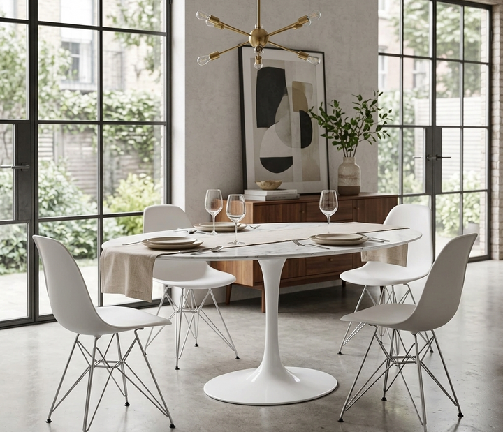 Modern dining room with a white round table and chairs, large windows, and abstract art on the wall.