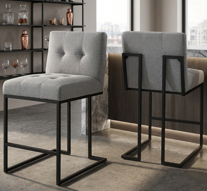 Two gray bar stools with black metal legs in a modern interior setting.