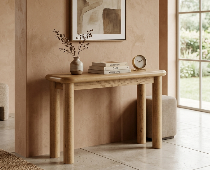 Wooden console table with decor items against a beige wall with a painting.